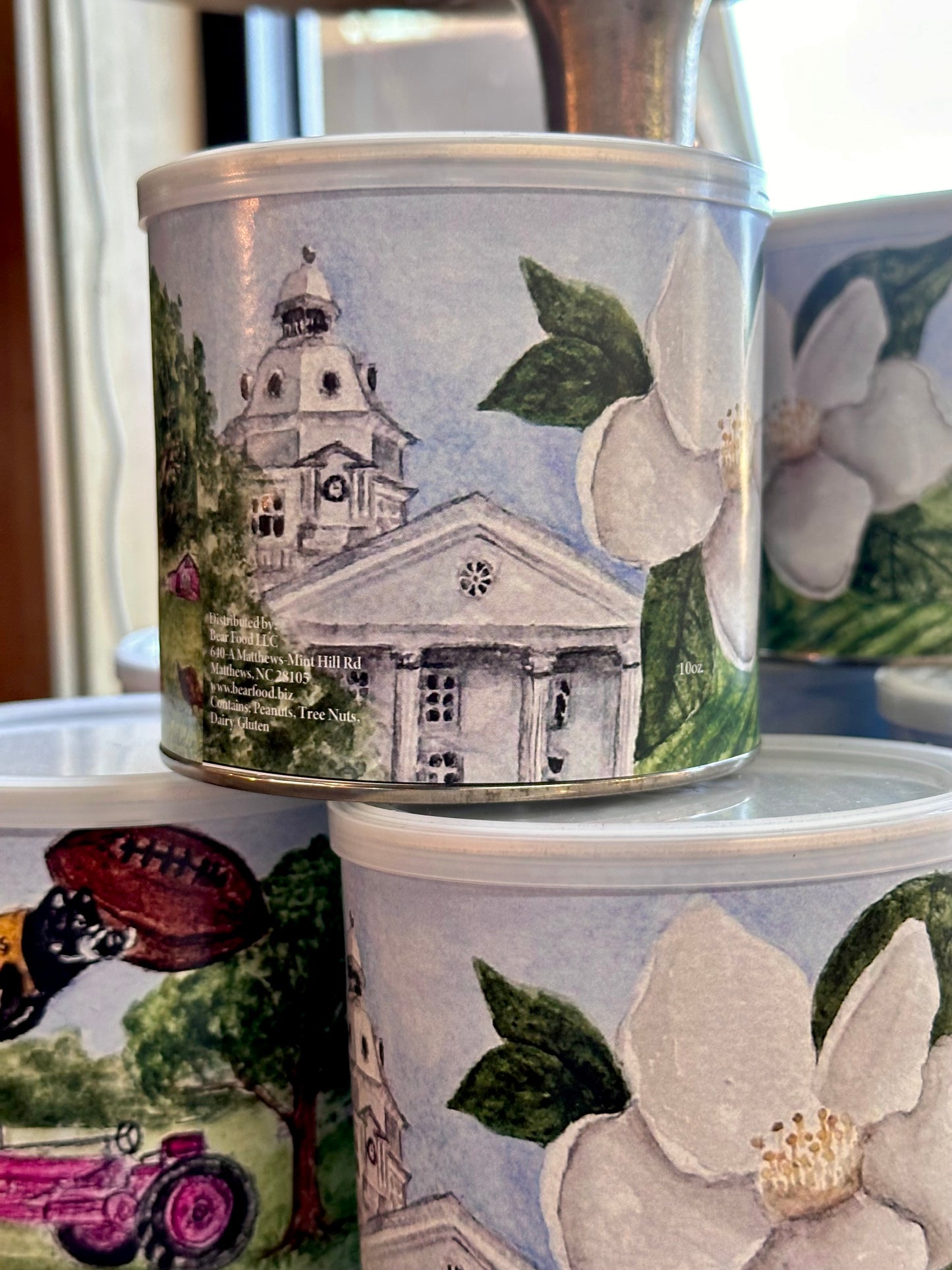 Decorative tins with architectural and floral designs on a surface.