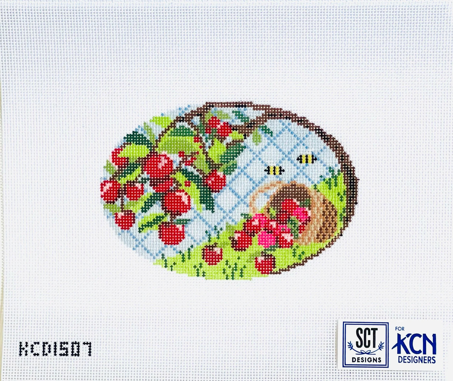 Cross-stitched design with cherries, a basket, and bees on a white background with 'KCN Designs' branding.