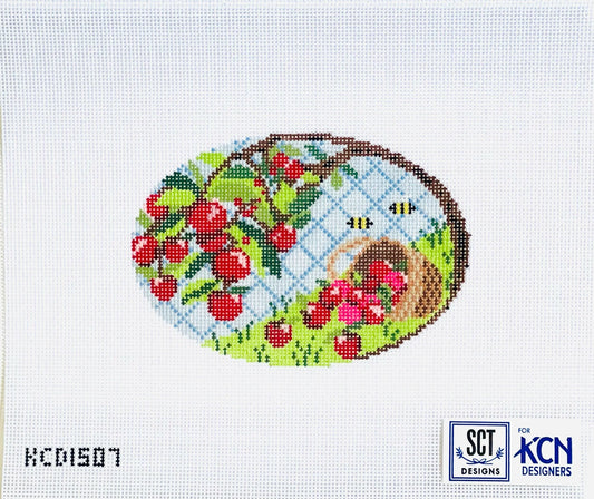 Cross-stitched design with cherries, a basket, and bees on a white background with 'KCN Designs' branding.