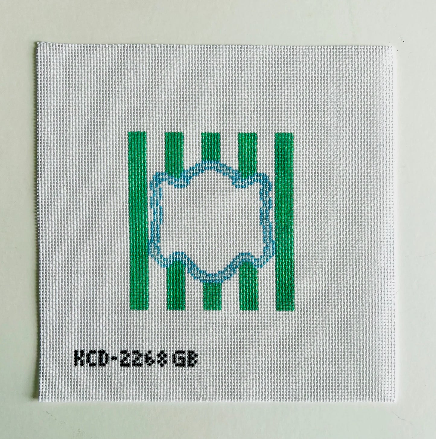 Textile sample with green stripes and a circular design on a light gray background