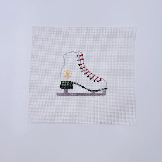 Cross-stitched ice skate on a white fabric background
