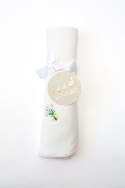 Folded baby blanket with a label on a white background