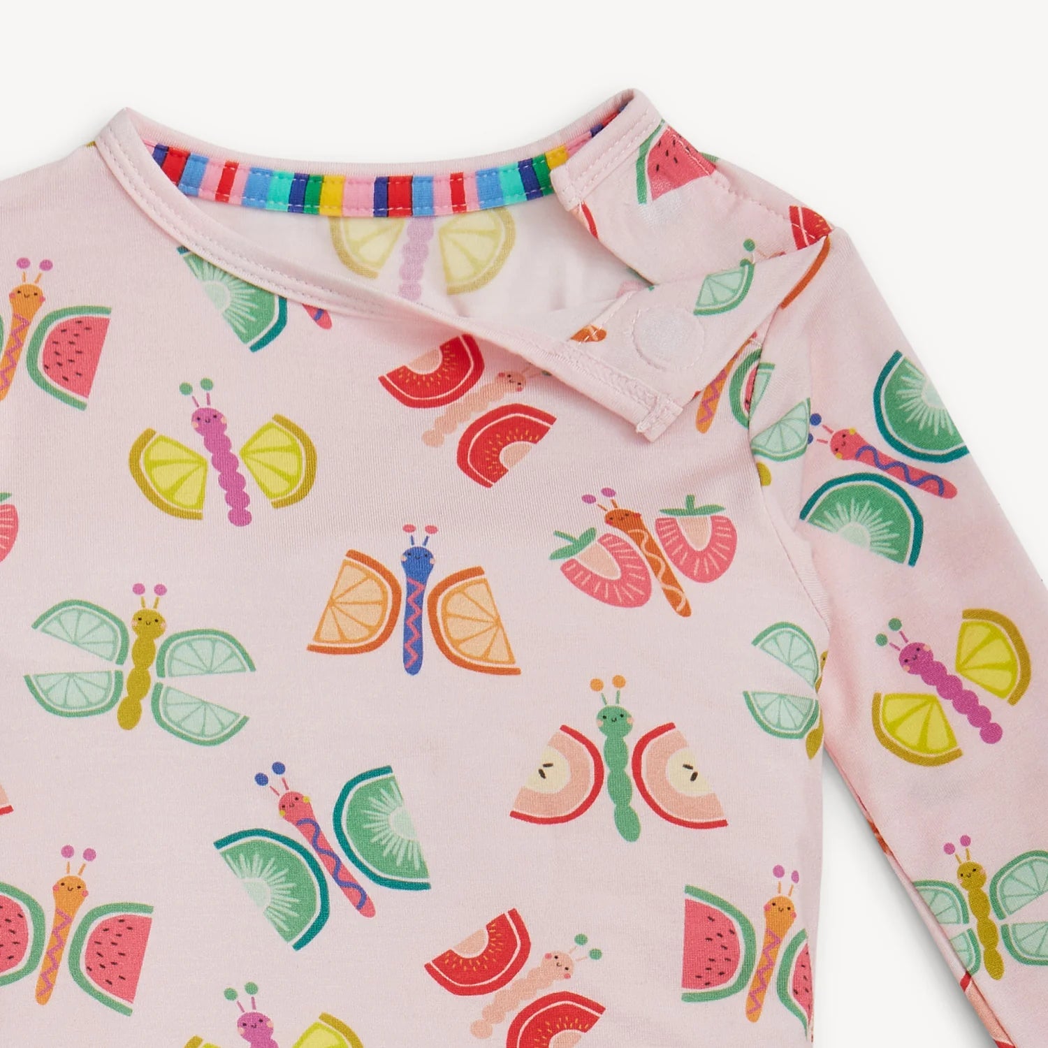 Children's pink long-sleeve shirt with colorful insect and fruit pattern on a white background