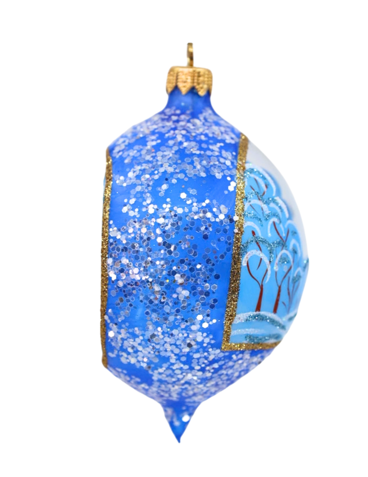 A blue Christmas ornament with silver glitter on one side and a hand-painted winter tree scene on the other, finished with gold trim and a gold hanging loop.