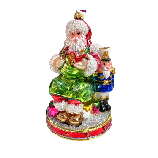 Decorative Christmas ornament with a green glass Santa Claus figure and a nutcracker on a white background.
