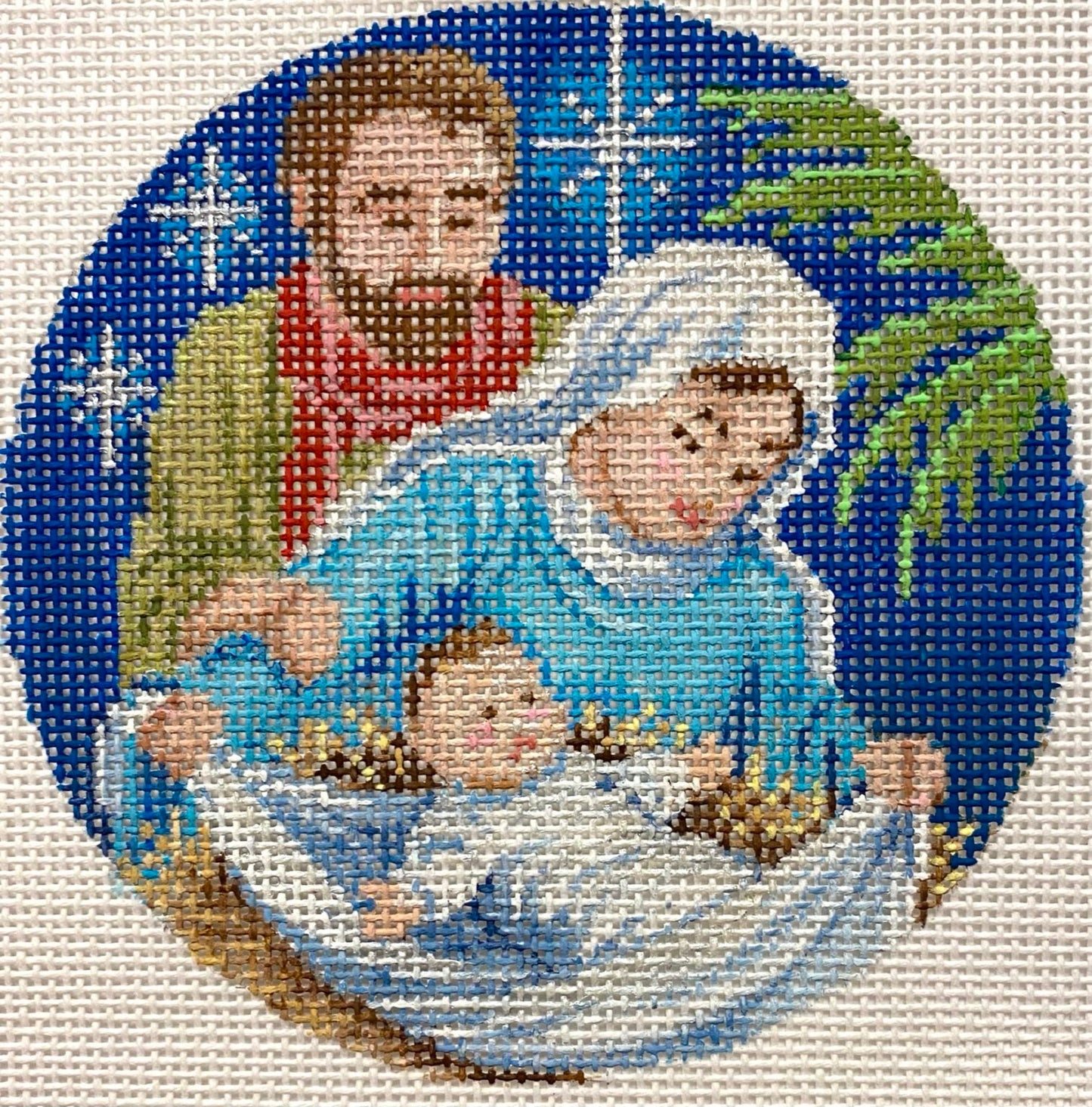 Decorative needlepoint of the nativity scene with Mary, Joseph, and baby Jesus.