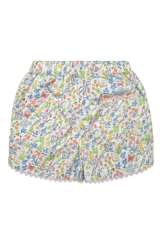A pair of girl's shorts featuring an all-over multicolor floral and botanical print on a white base, finished with a delicate scalloped edge.