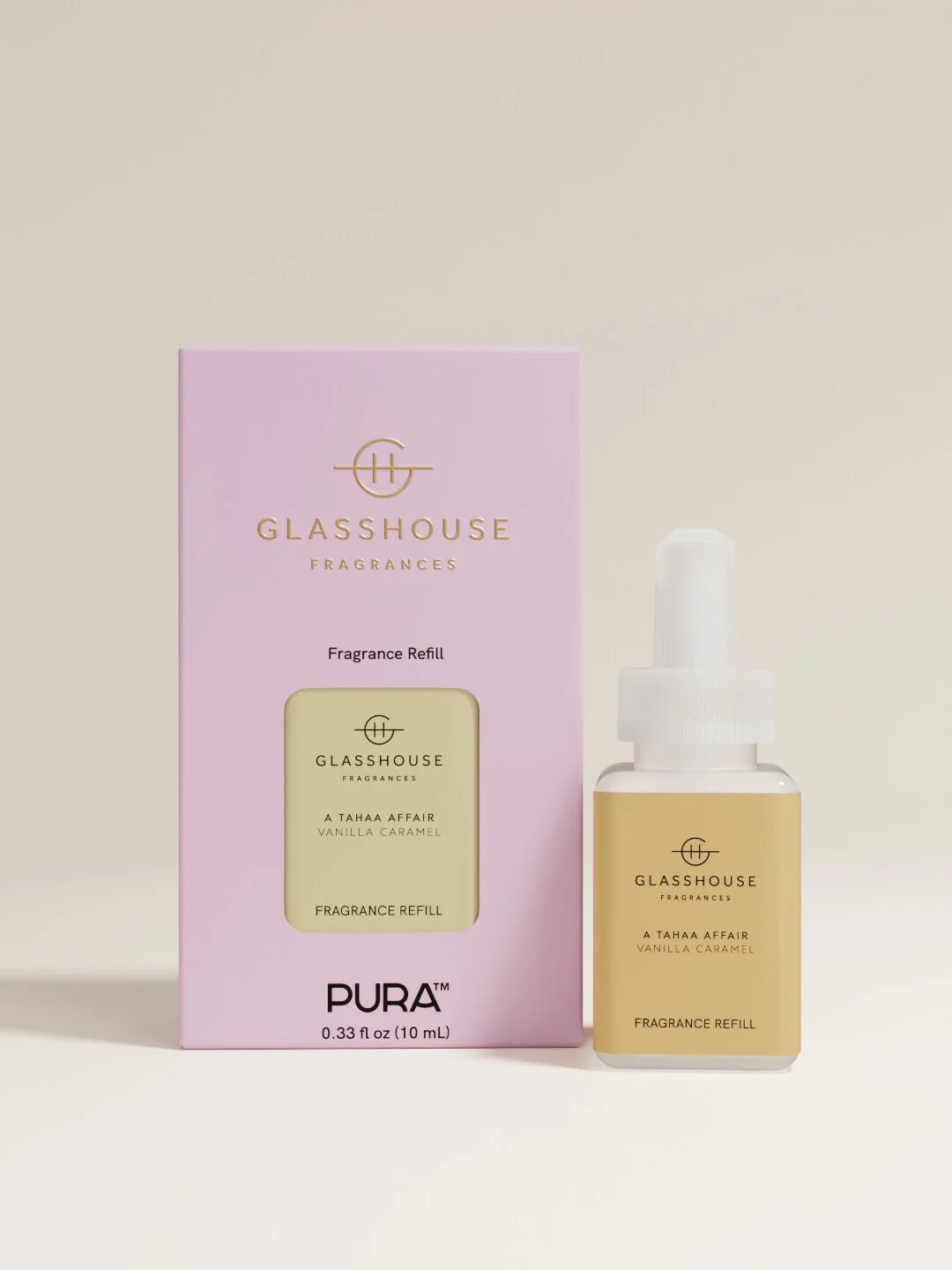 A fragrance refill bottle with a white dropper cap stands beside its light pink retail box. The bottle has a pale yellow label reading GLASSHOUSE FRAGRANCES, and the box is lavender with gold text and a matching yellow label panel.