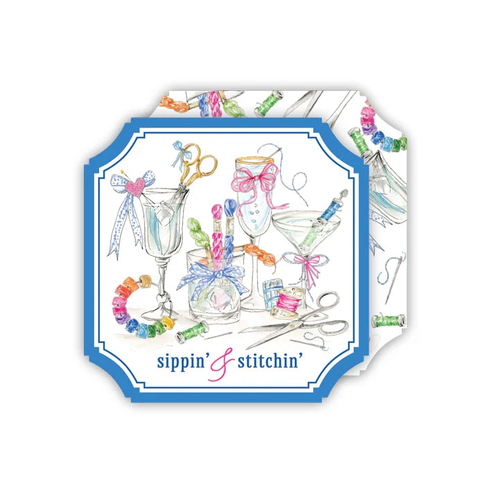 A square decorative card or print with rounded corners, featuring a blue border and a watercolor-style illustration of sewing and cocktail-themed items such as scissors, glasses, bows, and colorful thread spools. The text 'sippin' & stitchin'' appears at the bottom.