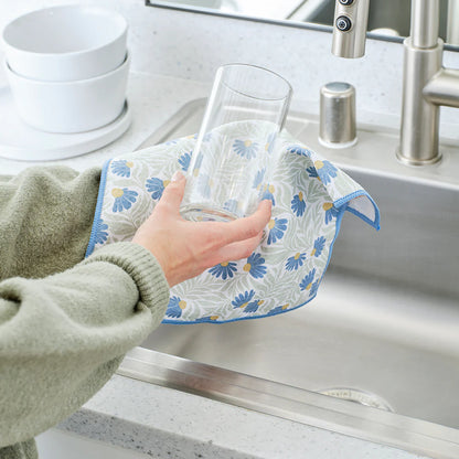 Person using a floral dish drying rack to dry glasses in a kitchen sink.