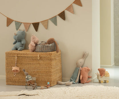 Wicker basket with toys and a decorative banner in a child's room