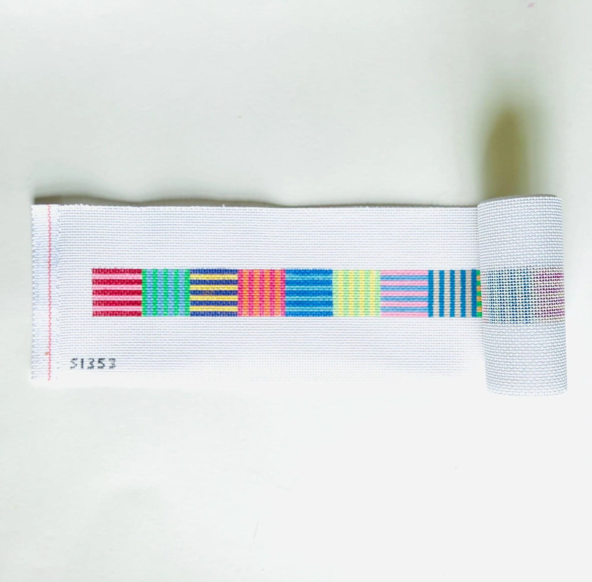 needlepoint canvas with colorful stripes on a white background
