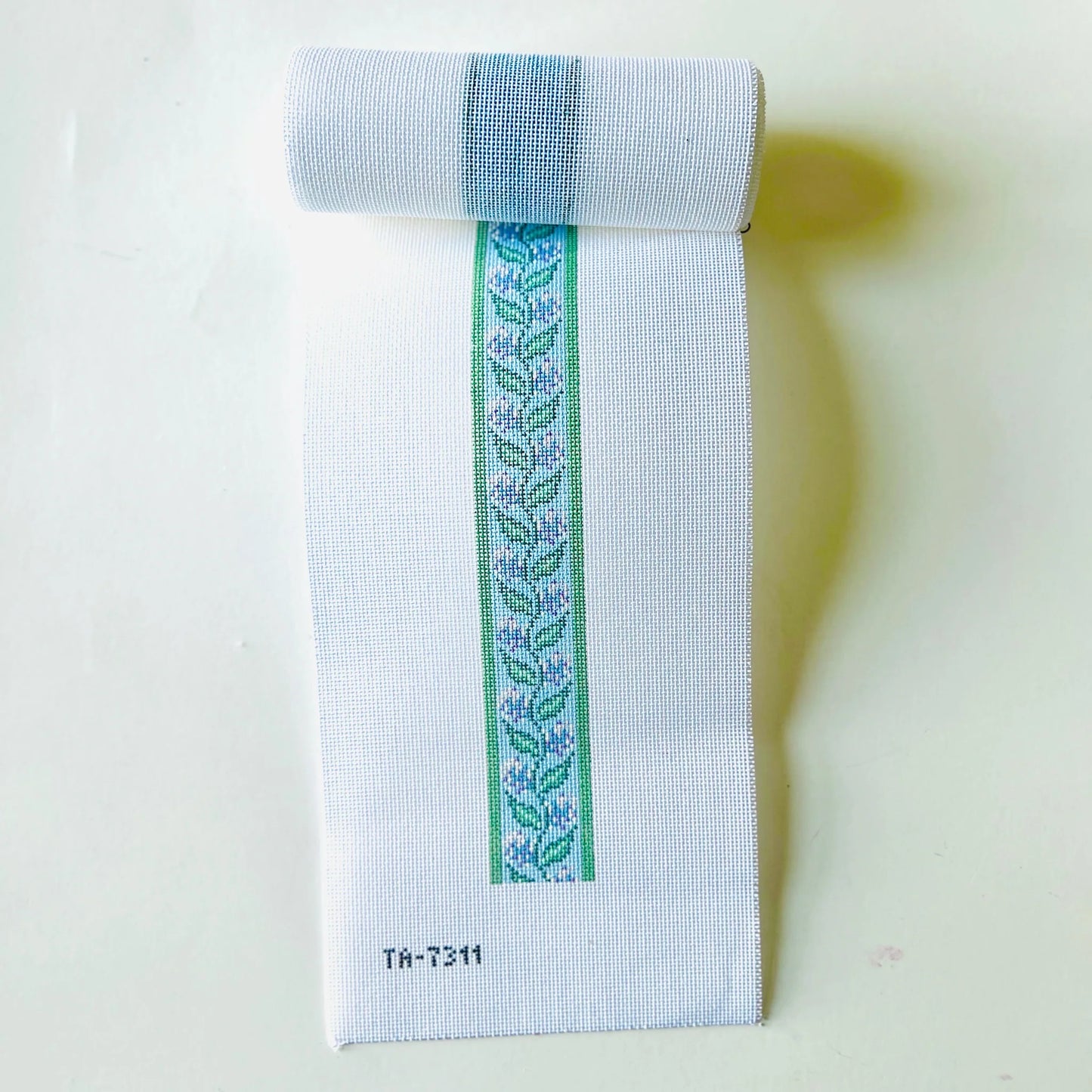 Embroidered fabric strip with floral pattern on a white background