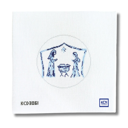 A square white needlepoint canvas featuring a blue embroidered nativity scene with Mary, Joseph, baby Jesus in a manger, and a star. The canvas has the printed code 'KCD3061' in the bottom-left corner and a blue 'KCN' logo in the bottom-right corner.