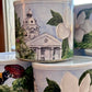 Decorative tins with architectural and floral designs on a surface.