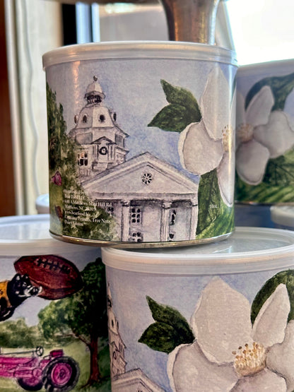 Decorative tins with architectural and floral designs on a surface.