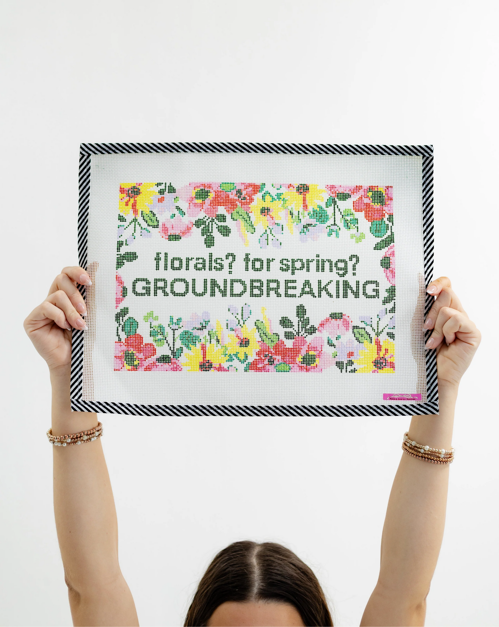 Person holding a framed poster with floral design and text on a white background