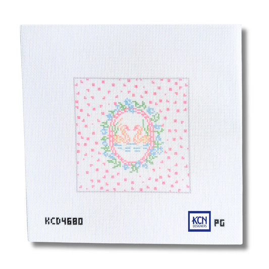 A square white needlepoint canvas featuring a central embroidered-style swan design with pink hearts around it, shown on a white background with printed codes and a KCN logo.
