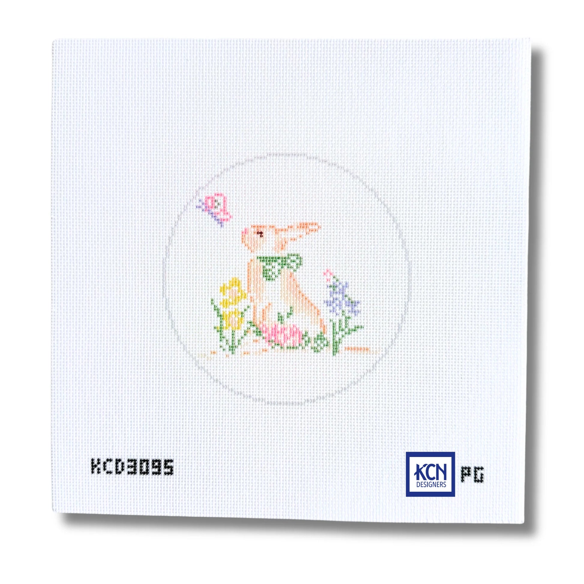 A square white needlepoint canvas featuring a stitched design of a rabbit in a circle with flowers and a butterfly. The canvas includes printed text 'KCD3095' on the bottom left and a 'KCN Pictoric' logo on the bottom right.