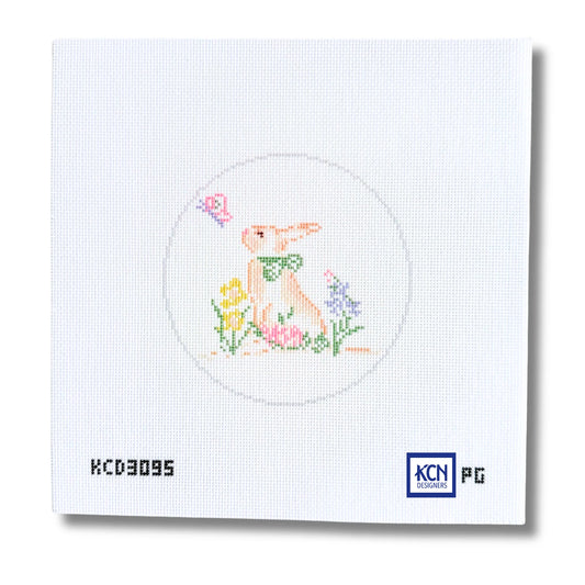A square white needlepoint canvas featuring a stitched design of a rabbit in a circle with flowers and a butterfly. The canvas includes printed text 'KCD3095' on the bottom left and a 'KCN Pictoric' logo on the bottom right.