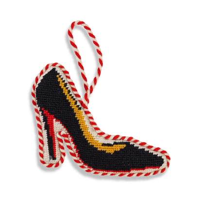 Decorative high-heeled shoe ornament with red and white striped shoelace on a white background