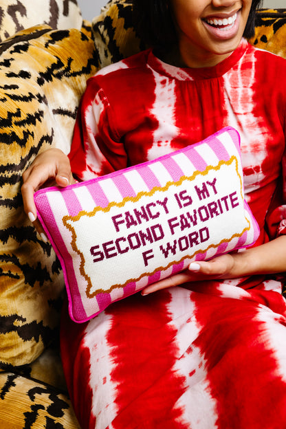 Person holding a pillow with text in a red and white striped pattern
