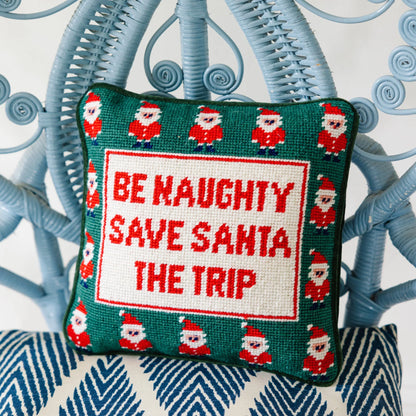 Decorative pillow with Christmas-themed text and Santa Claus pattern on a blue and white chair.
