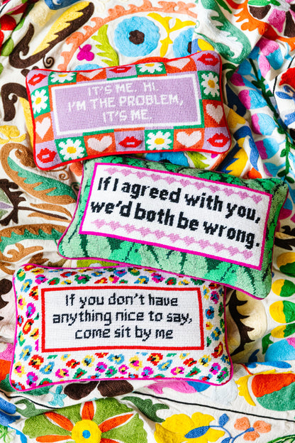 Colorful pillows with humorous sayings on a patterned fabric background