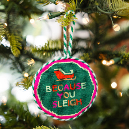 Decorative Christmas ornament with text and a sleigh design on a tree.