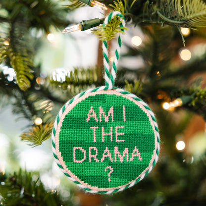 Green ornament with 'AM I THE DRAMA?' text on a Christmas tree.