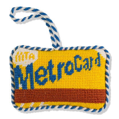 Knitted toy resembling a MetroCard with blue and white rope handle on a white background