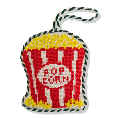 Decorative knitted popcorn bag with 'Pop Corn' text on a white background
