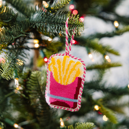 Decorative ornament shaped like a bag of fries hanging on a Christmas tree.