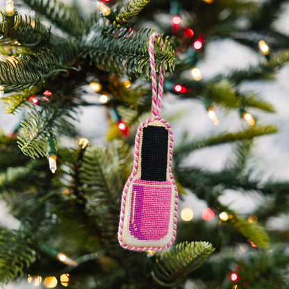 Pink and black crocheted pouch ornament hanging on a Christmas tree.