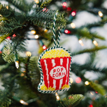 Decorative popcorn bucket ornament hanging on a Christmas tree.