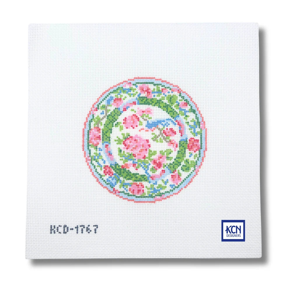 A chinoiserie patterned plate with pink roses and leaves.