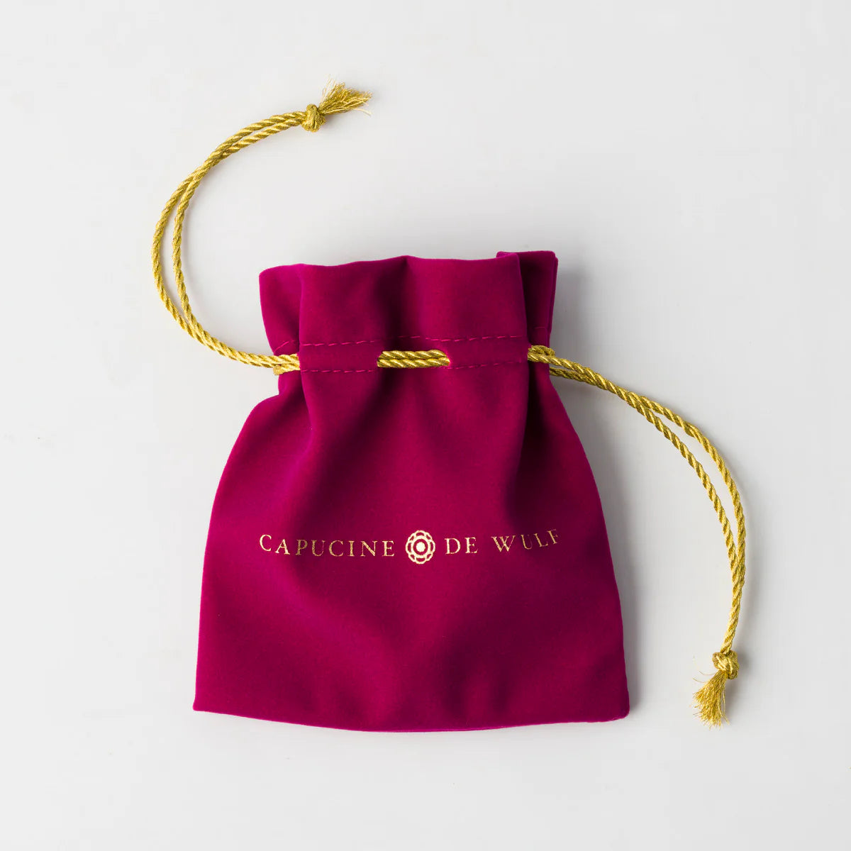 Red drawstring bag with 'Capucine de Wulf' branding on a white background