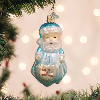 Christmas ornament of a blue Santa Claus with 'Baby's 1st Christmas' text, hanging on a tree.