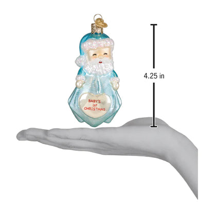 Decorative Christmas ornament of a blue Santa Claus holding a heart with 'Baby's 1st Christmas' text, shown on a hand for scale.