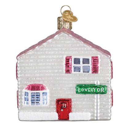 Decorative glass house ornament with a red door and 'Lovely Dr' sign on a white background