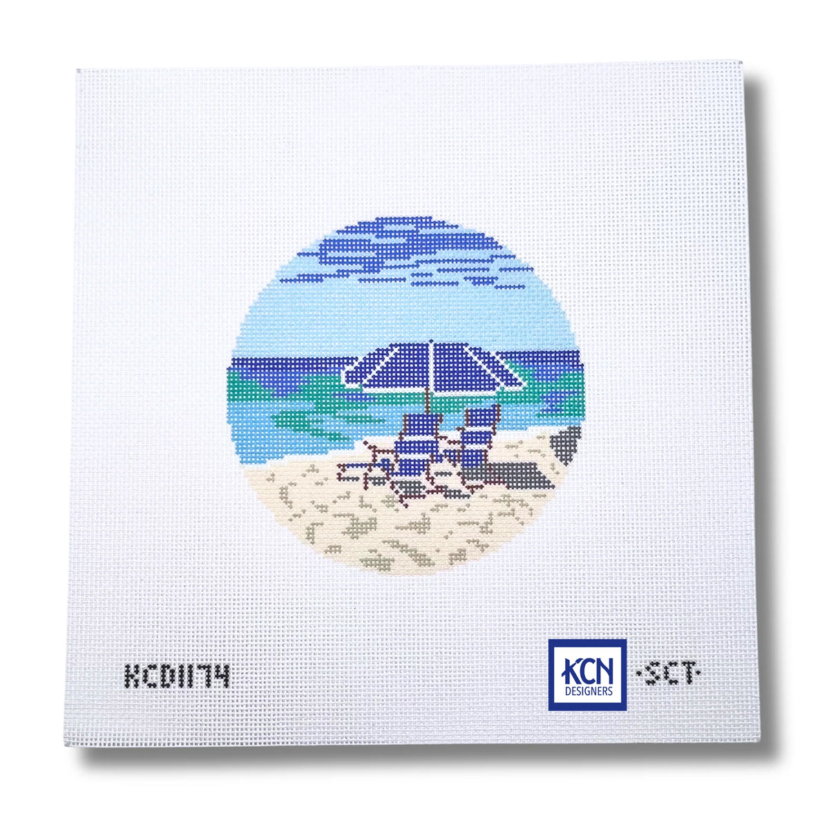 needlepoint canvas with round design of beach chairs and a beach umbrella on the beach 