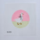 Cross-stitched design of a stork with baby shoes and socks on a pink and beige circle background.