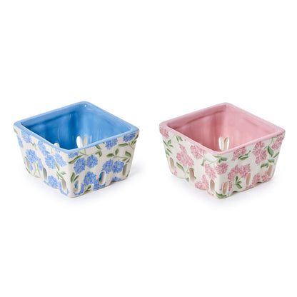 Two square ceramic berry crates with floral patterns, one in blue and one in pink.
