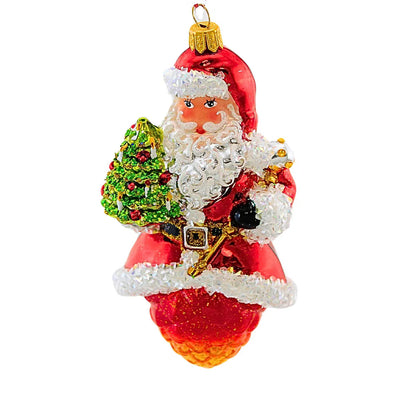 Decorative Christmas ornament of a Santa Claus holding a tree on a white background