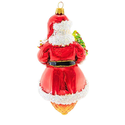 Glass ornament of Santa Claus with a white beard and green holly leaves on a white background
