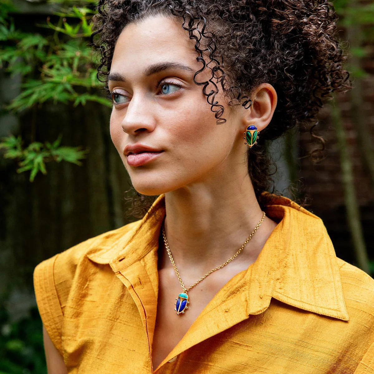 Woman wearing colorful earrings and a necklace outdoors