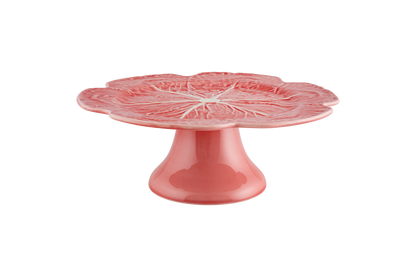 Pink ceramic cake stand with floral design on a white background