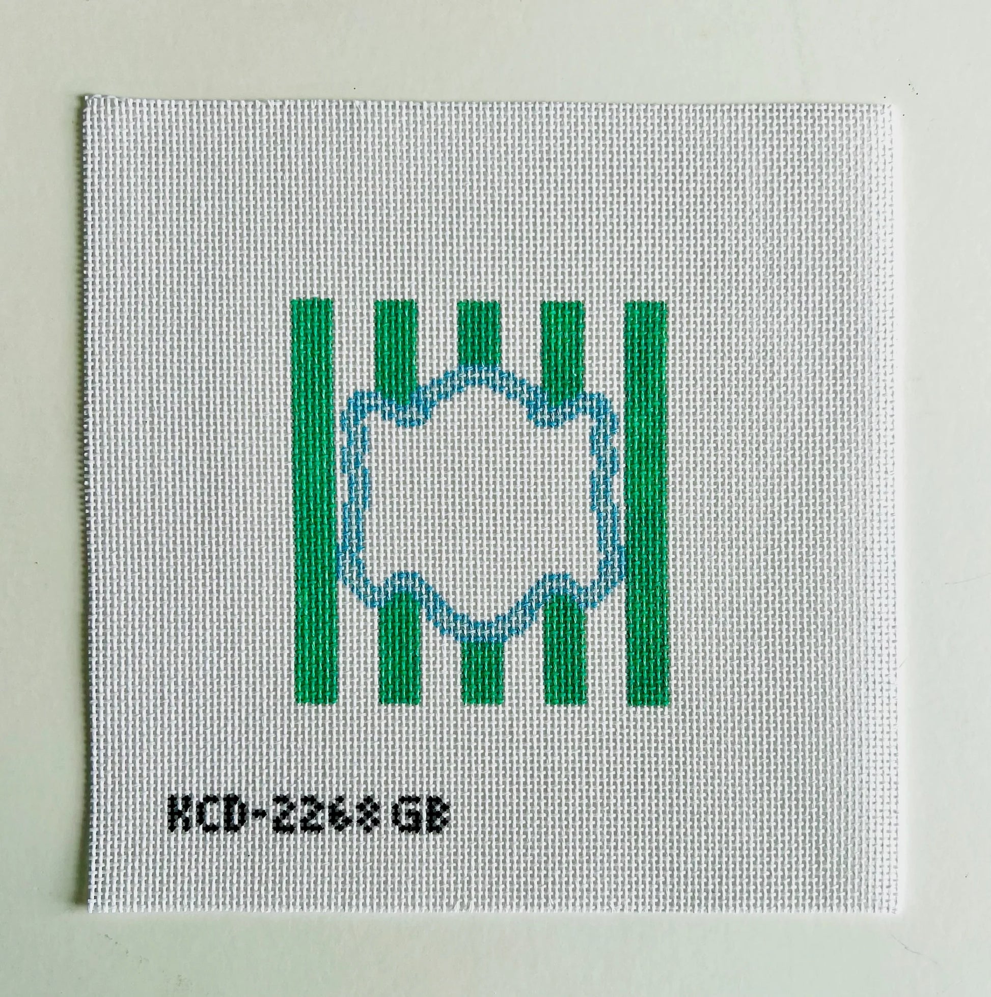 Textile sample with green stripes and a circular design on a light gray background