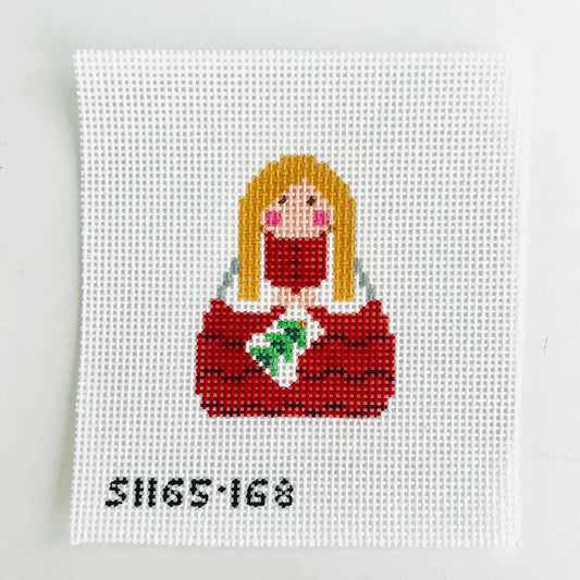 needlepoint design of a person with long blonde hair wearing a red outfit on a white background.