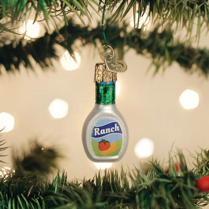 Ranch dressing bottle ornament hanging on a Christmas tree with lights in the background